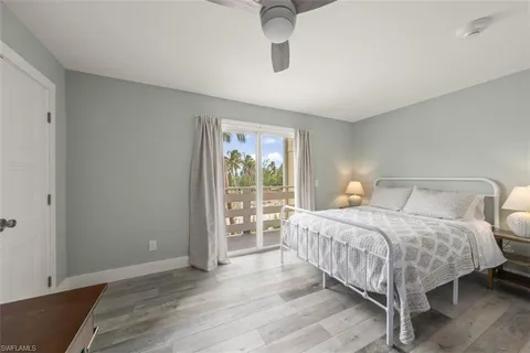 a bedroom with a large bed and wooden floor