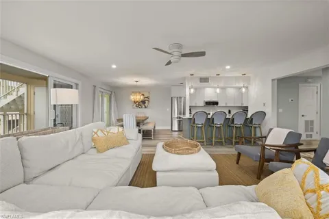 a living room with furniture kitchen view and a large window