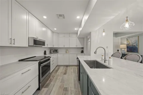 a kitchen with sink a microwave and cabinets