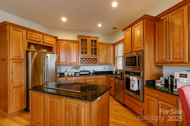 a kitchen with stainless steel appliances granite countertop a refrigerator a stove top oven a sink and dishwasher