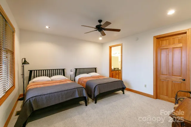 a bedroom with two beds and a ceiling fan