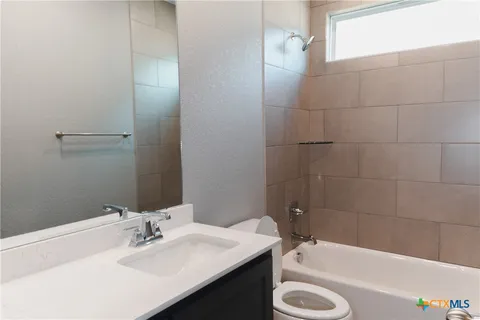 a bathroom with a sink a bathtub and a window