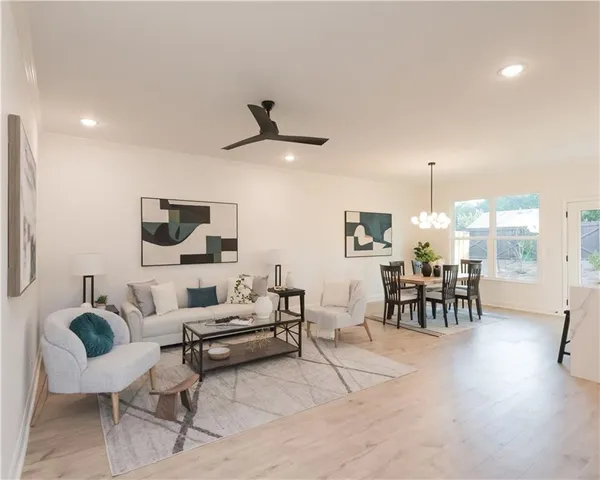 a living room with furniture and a flat screen tv with kitchen view