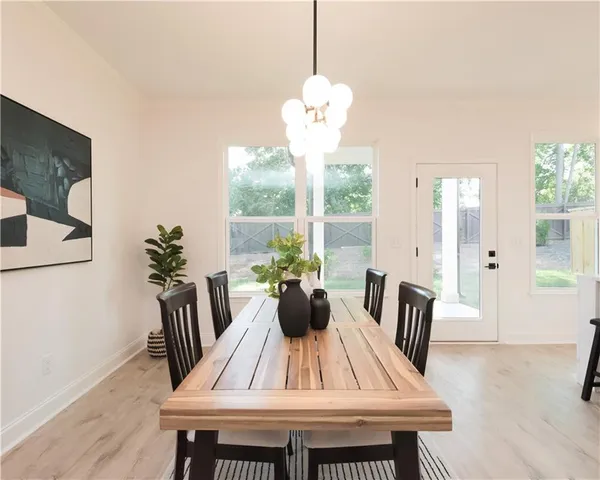 a view of dining room and livingroom with furniture wooden floor a rug a potted plant and a chandelier