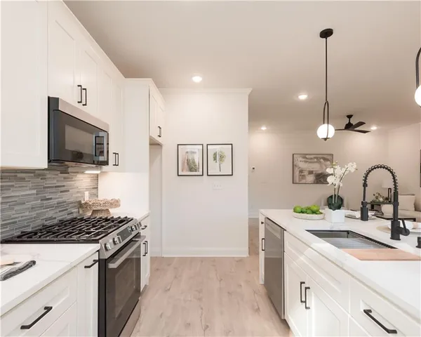a kitchen with a sink and a stove top oven with wooden floor