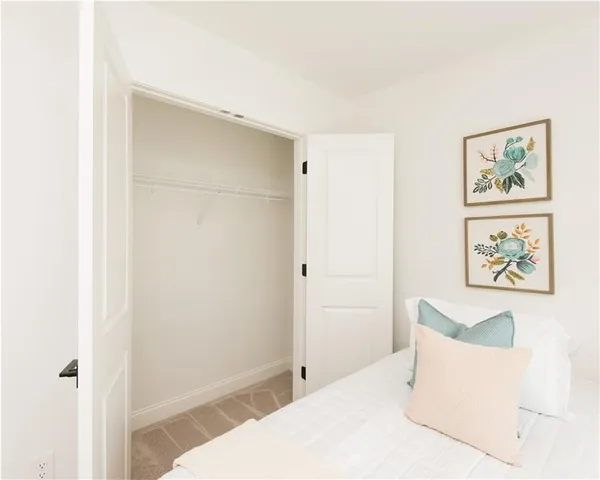 a bedroom with a bed a window and a chandelier