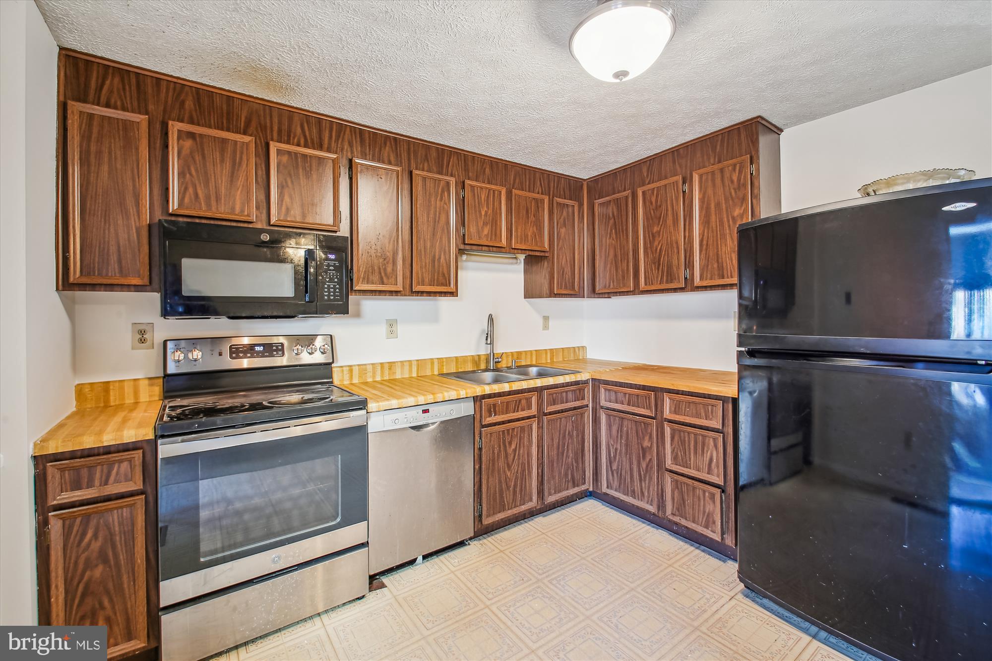 1474 Gesna Drive Hanover, MD 21076 - Photo 18 of 39 a kitchen with granite countertop a refrigerator stove and microwave