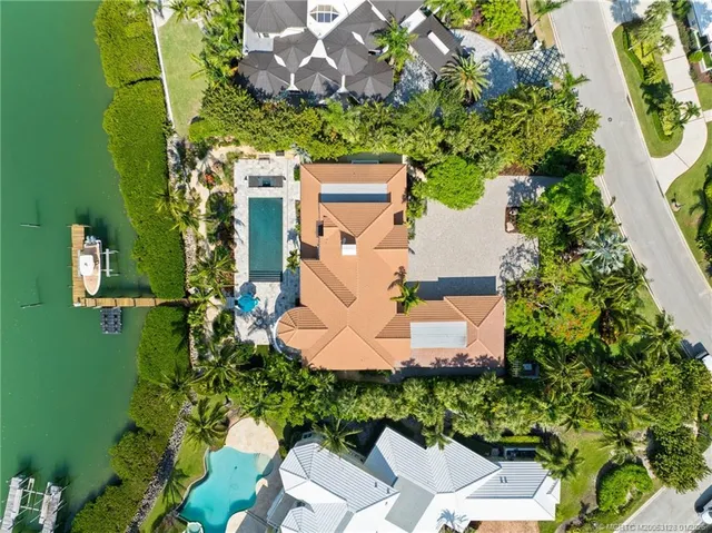 an aerial view of a residential houses with outdoor space and lake view