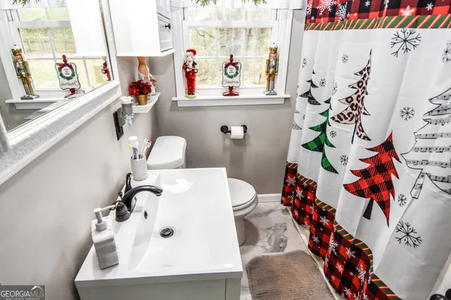 a bathroom with a sink mirror and toilet