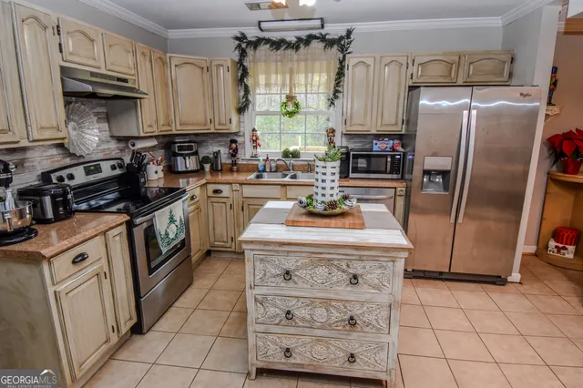 a kitchen with stainless steel appliances granite countertop a stove a refrigerator a sink dishwasher and white cabinets