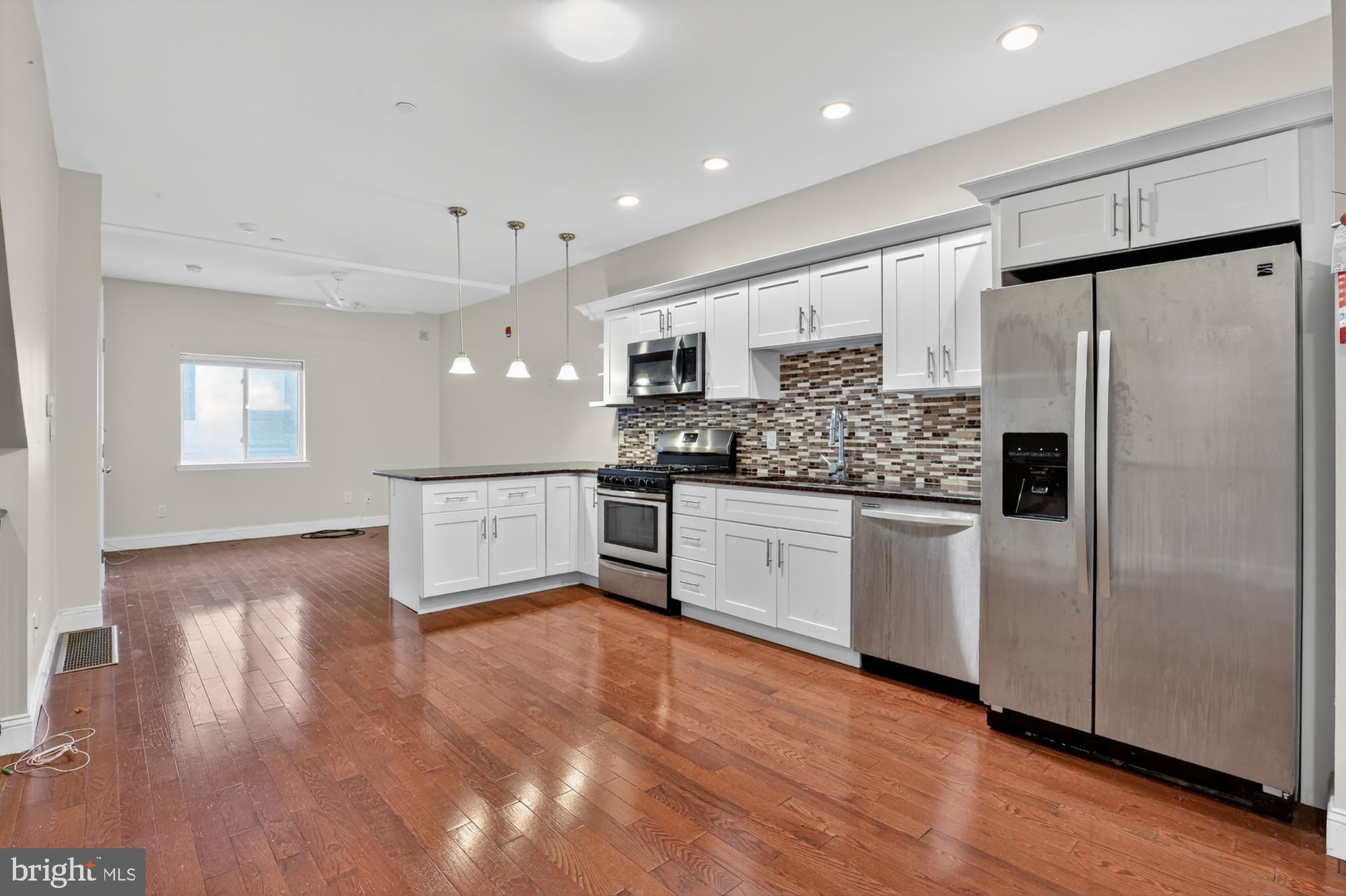 a kitchen with stainless steel appliances a refrigerator sink and microwave