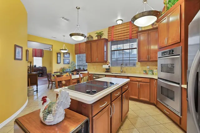 a kitchen with stainless steel appliances granite countertop a sink a stove and a refrigerator