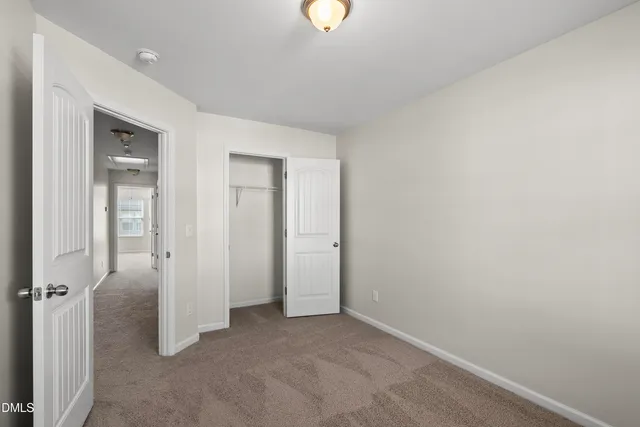 an empty room with closet and mirror