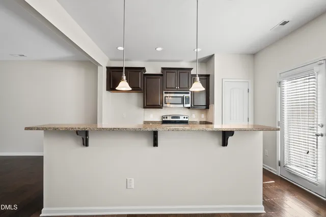 a kitchen with stainless steel appliances a refrigerator sink and microwave