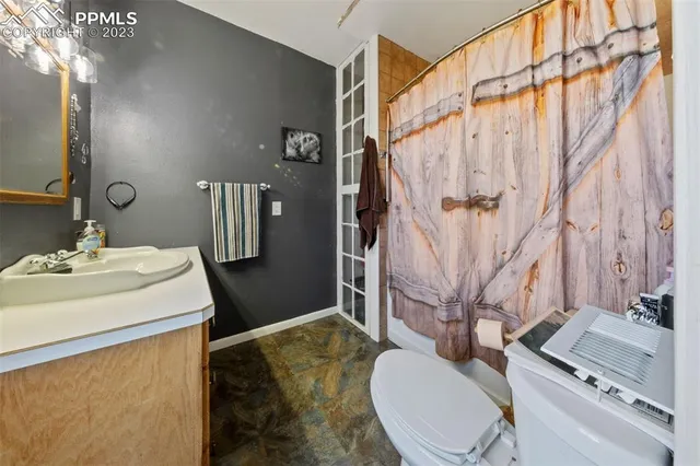 a bathroom with a sink a toilet and shower curtain