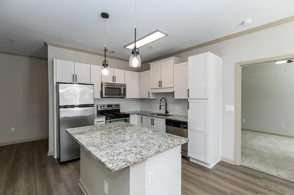 a kitchen with kitchen island a counter space a sink appliances and cabinets