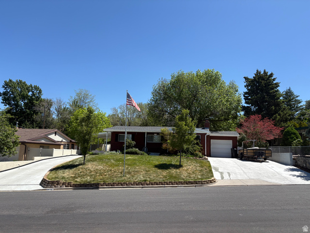 Red-sided residence featuring a single-car garage and a paved driveway