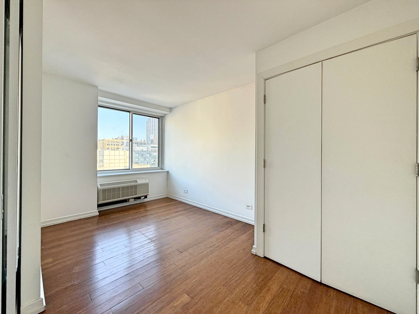 211 East Ohio Street, Unit 2707 Chicago, IL 60611 - Photo 16 of 43 an empty room with wooden floor and windows