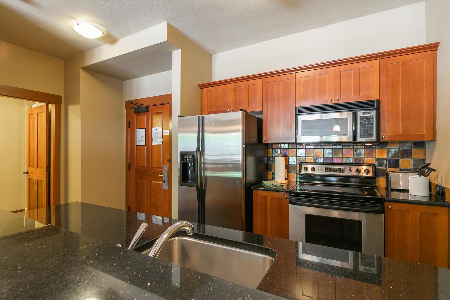 1750 Village East Road, Unit 5306 Olympic Valley, CA 96146 - Photo 5 of 21 a kitchen with stainless steel appliances granite countertop a refrigerator and a stove top oven