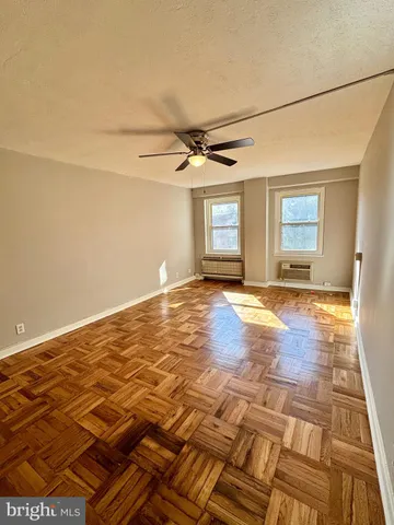 a view of a livingroom with wooden floor and a ceiling fan