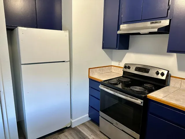 a white refrigerator freezer and a stove sitting inside of a kitchen