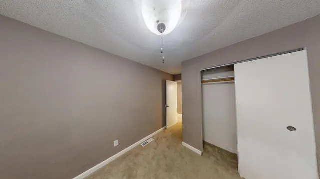 a view of a hallway with a chandelier fan