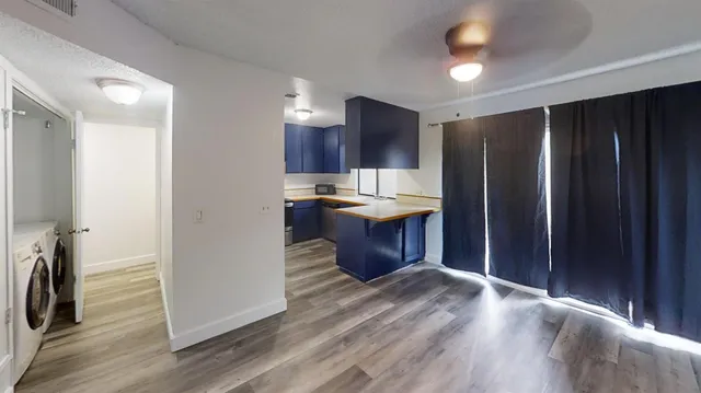 a kitchen with stainless steel appliances granite countertop a refrigerator a sink and a stove with wooden floor