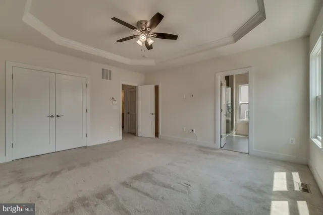 an empty room with chandelier fan