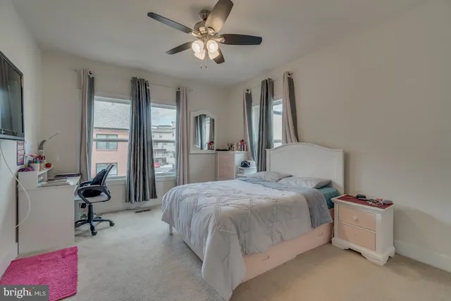 a spacious bedroom with a bed and a chandelier