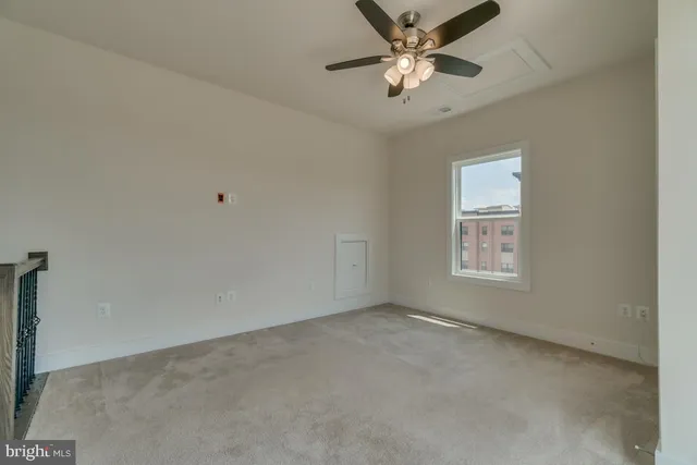 an empty room with a window and a fan