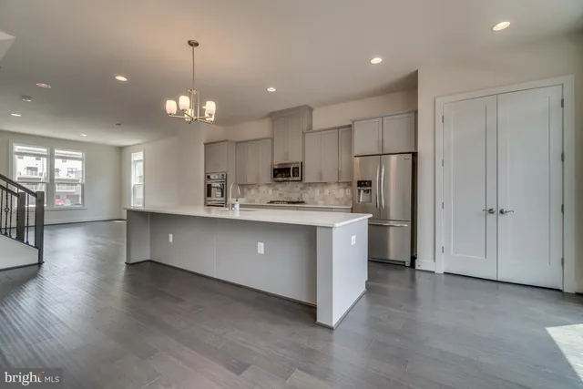 a large kitchen with stainless steel appliances kitchen island a large counter space a sink appliances and cabinets