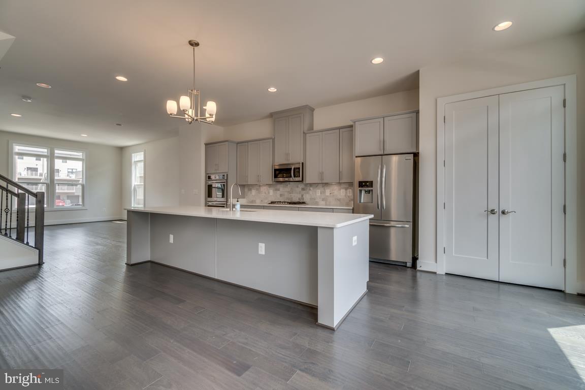 44721 Ellsworth Terrace Ashburn, VA 20147 - Photo 8 of 51 a large kitchen with stainless steel appliances kitchen island a large counter space a sink appliances and cabinets