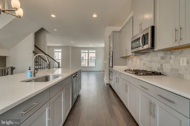 a kitchen with stainless steel appliances sink stove microwave and cabinets