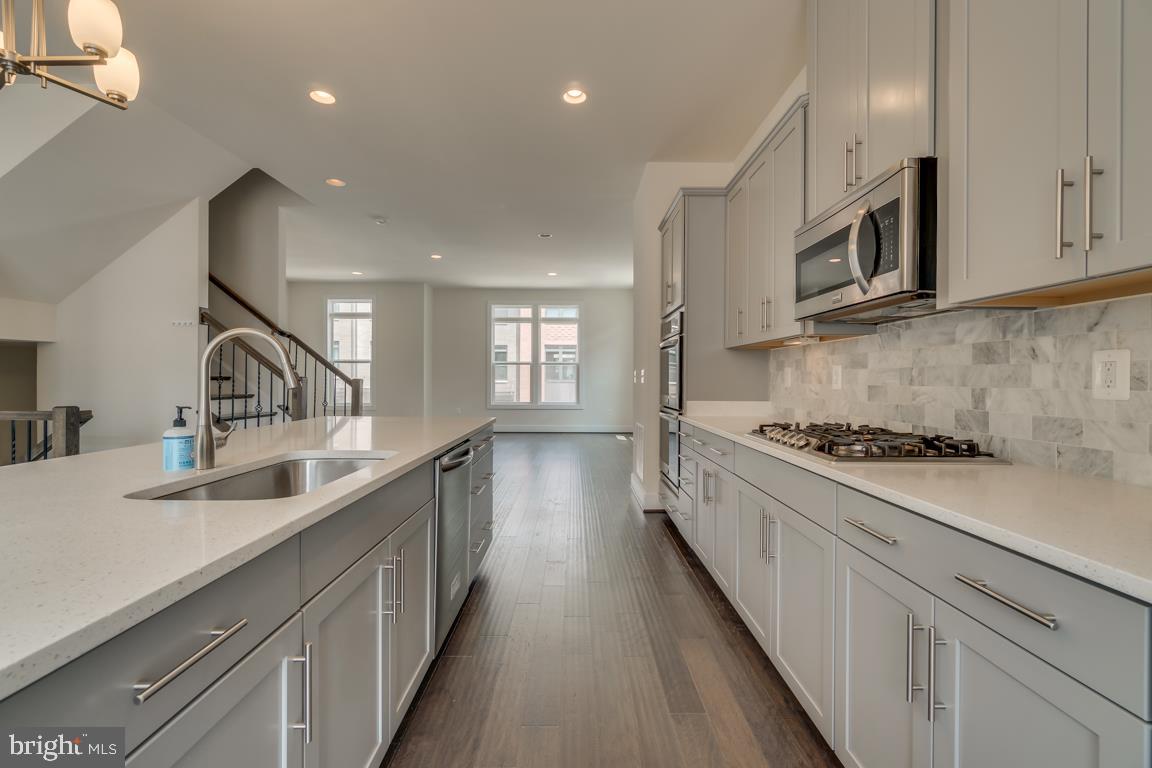44721 Ellsworth Terrace Ashburn, VA 20147 - Photo 9 of 51 a kitchen with stainless steel appliances sink stove microwave and cabinets
