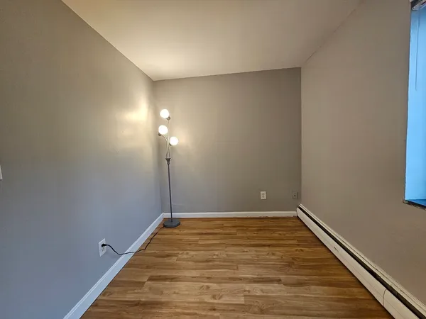 a view of a room with wooden floor and white walls