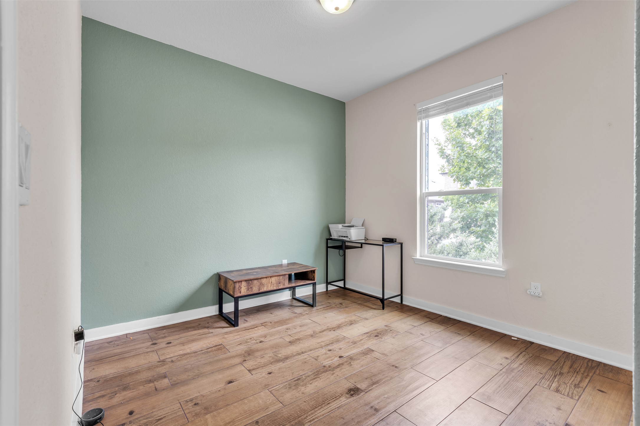 128 Kavanaugh Street Georgetown, TX 78628 - Photo 11 of 13 Room featuring wood-finish flooring, a double-hung window, and a recessed ceiling light