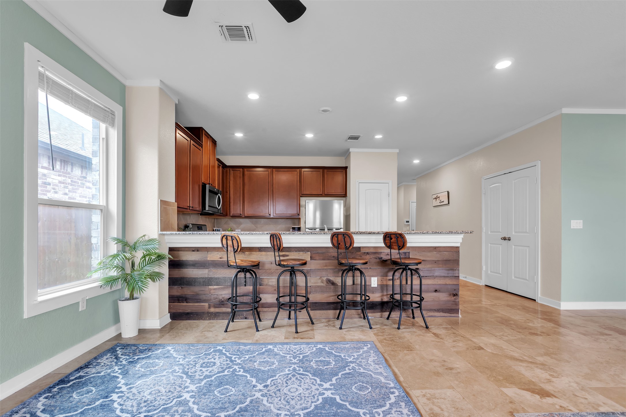 128 Kavanaugh Street Georgetown, TX 78628 - Photo 2 of 13 Kitchen features wood cabinetry, stainless steel appliances, and a breakfast bar with a wood-finish facade