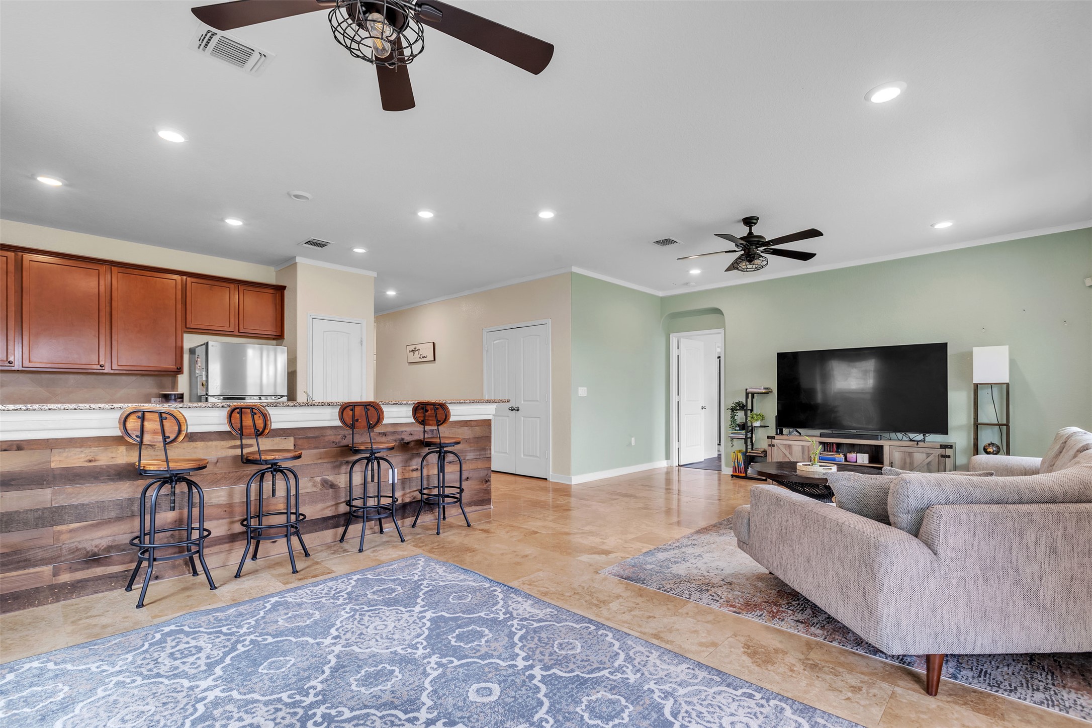 128 Kavanaugh Street Georgetown, TX 78628 - Photo 3 of 13 Open-concept living space featuring a breakfast bar with wood-finish paneling, recessed lighting, and tile flooring