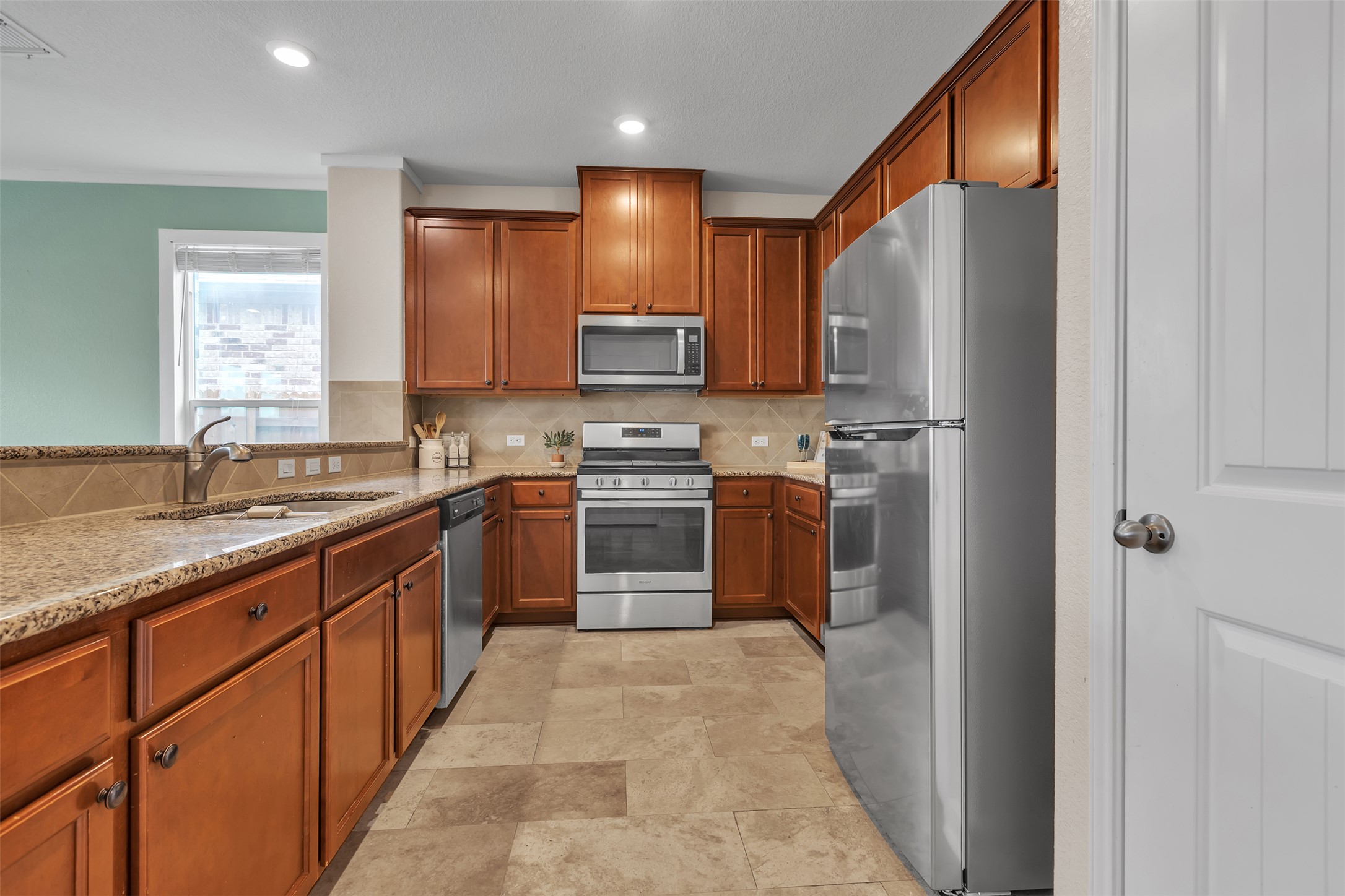 128 Kavanaugh Street Georgetown, TX 78628 - Photo 8 of 13 Kitchen featuring granite countertops, wood cabinetry, stainless steel appliances, and recessed lighting