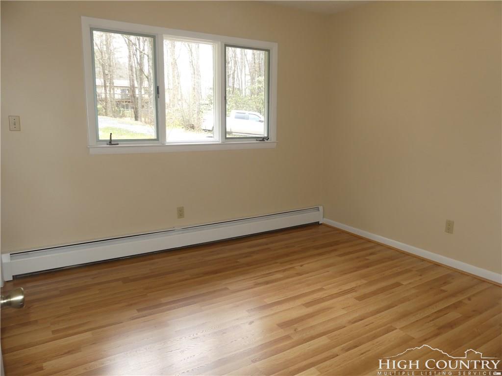 567 Deck Hill Road Boone, NC 28607 - Photo 11 of 25 an empty room with wooden floor and windows