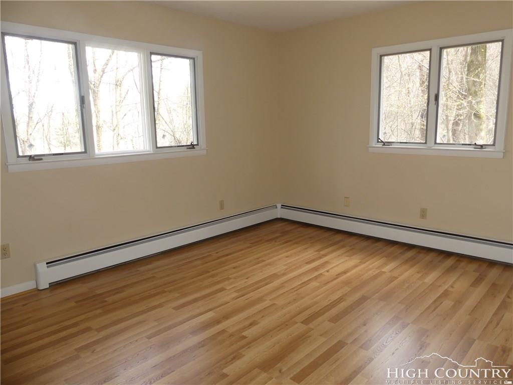 567 Deck Hill Road Boone, NC 28607 - Photo 12 of 25 a view of an empty room with wooden floor and a window