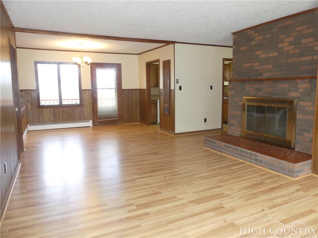 567 Deck Hill Road Boone, NC 28607 - Photo 3 of 25 a view of empty room with wooden floor and fireplace