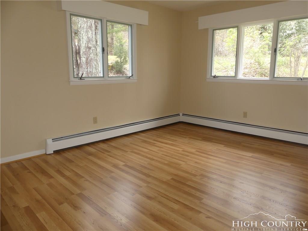 567 Deck Hill Road Boone, NC 28607 - Photo 9 of 25 a view of an empty room with wooden floor and a window