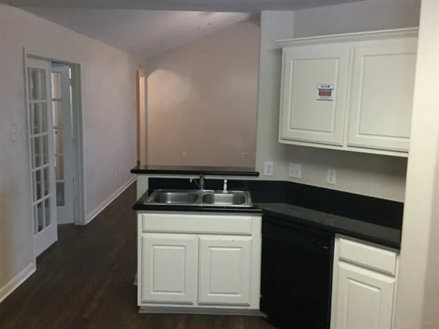 a kitchen with granite countertop white cabinets and a stove