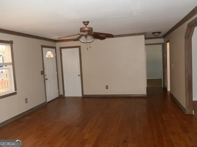 a view of a room with wooden floor and windows