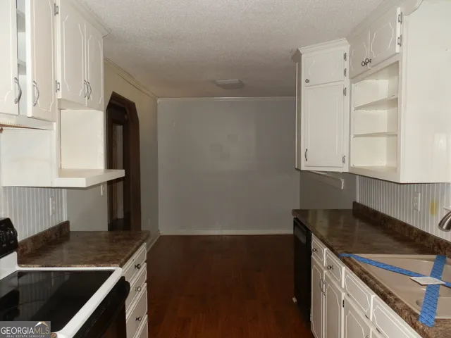 a kitchen with white cabinets and black appliances