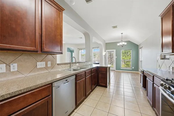 a kitchen with stainless steel appliances granite countertop a refrigerator and a sink
