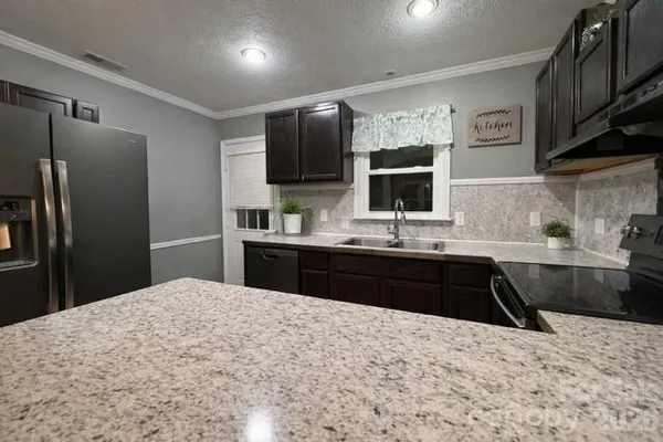a kitchen with a refrigerator sink and wooden cabinets