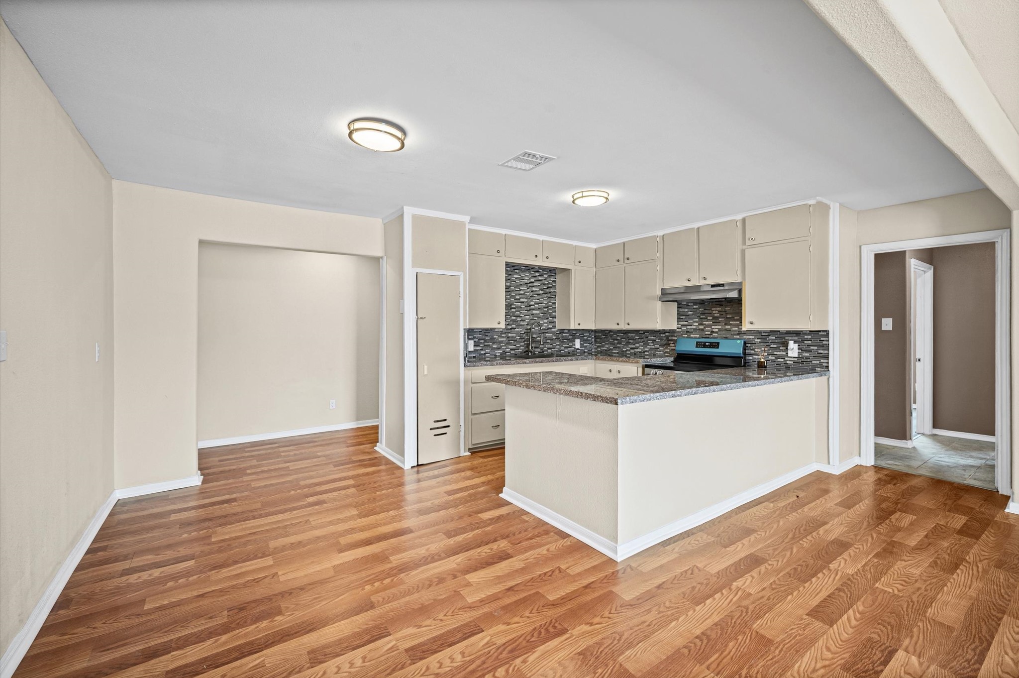10621 Lane Street Houston, TX 77029 - Photo 6 of 29 a kitchen with granite countertop a refrigerator and a stove top oven