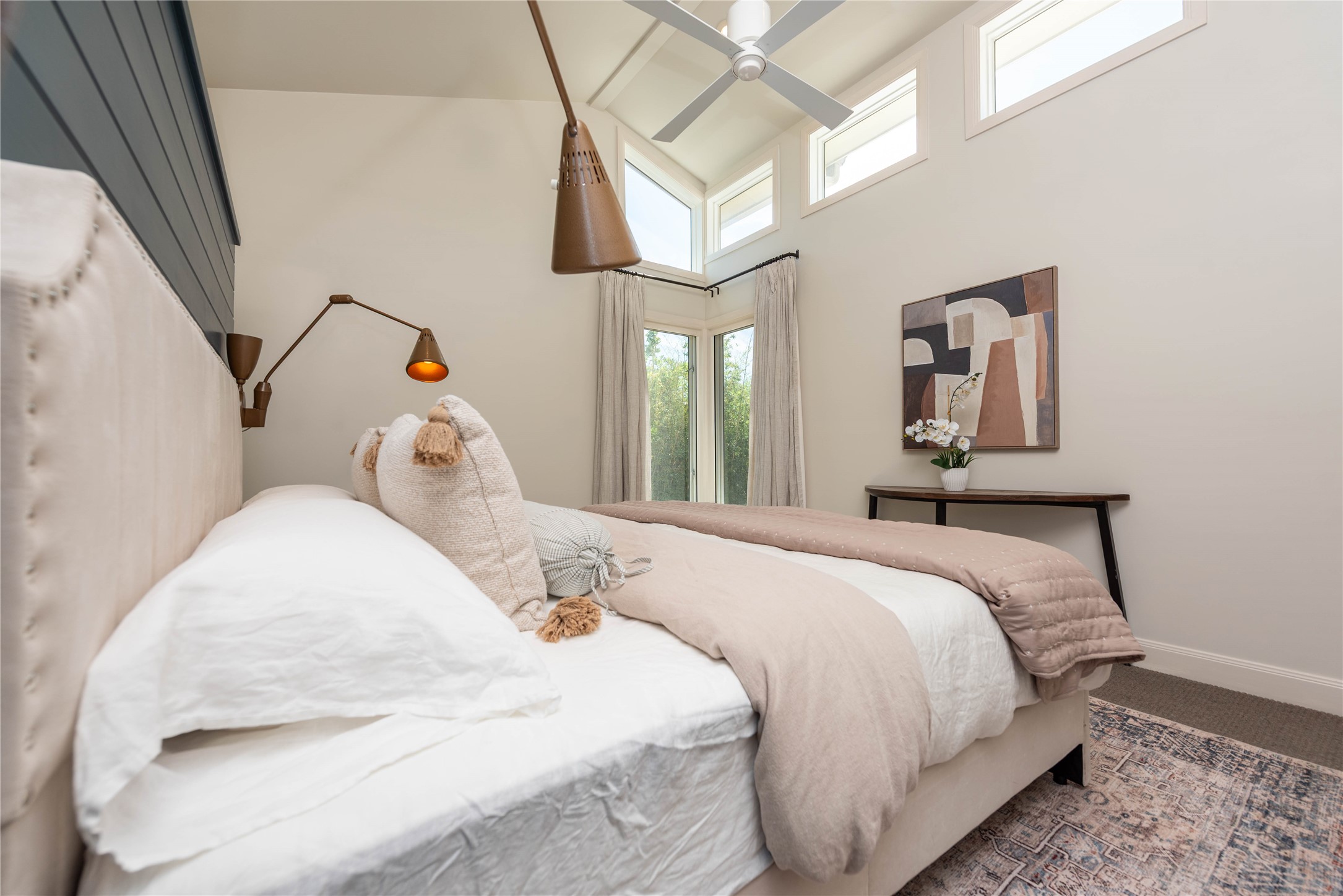 503 East 46th Street Austin, TX 78751 - Photo 14 of 25 Vaulted ceiling with a contemporary ceiling fan, multiple transom windows, and a corner window arrangement with drapery rods